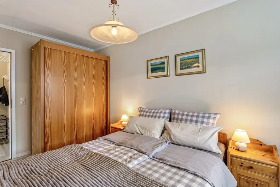 Schlafzimmer mit Doppelbett und Kleiderschrank