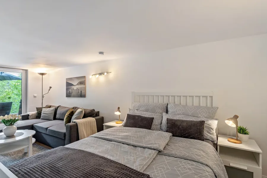 Wohn-Schlafbereich mit Doppelbett und Sofa
