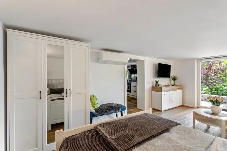 Kleiderschrank neben dem Schlafbereich, dahinter der Wohnbereich