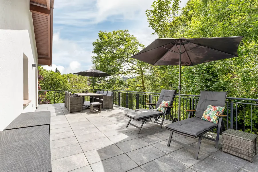 55 m² große Sonnenterrasse mit Liegen und Sonnenschirm